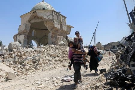 Displaced Iraqi civilians walk past the ruined Grand al-Nuri Mosque after fleeing from the Old City in Mosul, Iraq, June 30, 2017. REUTERS/Alaa Al-Marjani