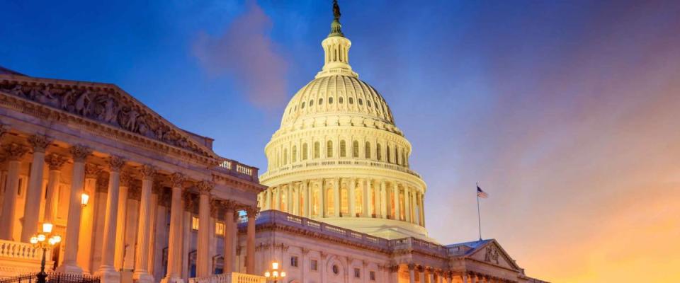 The United States Capitol building with the dome lit up at night.