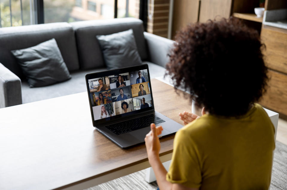 a woman talking to a screen of people on her laptop