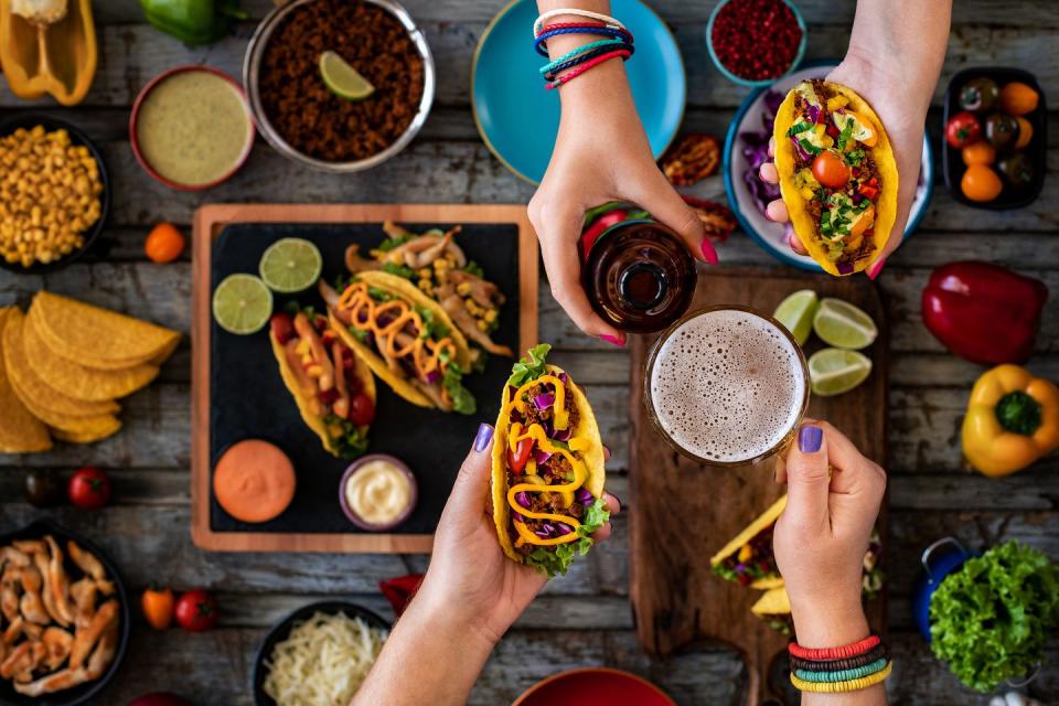 two people standing over a build your own taco bar