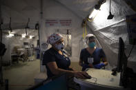 Nurses Karla Salazar, right, and Marisol Perez work in a tent set up to help treat COVID-19 patients at El Centro Regional Medical Center in El Centro, Calif., Tuesday, July 21, 2020. (AP Photo/Jae C. Hong)