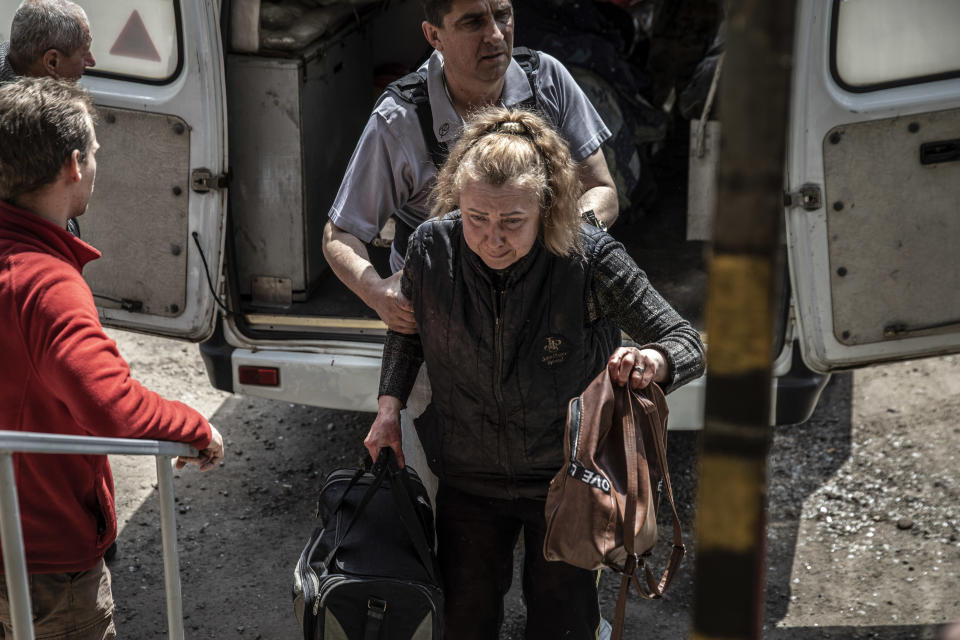 Olha, residente de Severodonetsk, Ucrania, recibe ayuda mientras desciende de la ambulancia que transportaba a su esposo, el martes 24 de mayo de 2022. (Finbarr O'Reilly/The New York Times)
