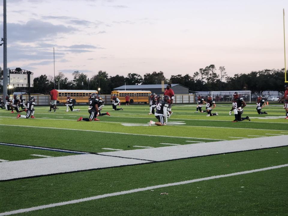 A.J. Ellender football players warm up before Friday's game against South Lafourche.