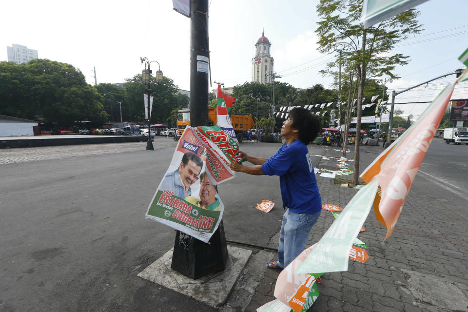 A Manila City public worker removes the campaign posters, mostly that of incumbent Mayor and former President Joseph "Erap" Estrada around the Manila City Hall, a day after the country's midterm elections Tuesday, May 14, 2019 in Manila, Philippines. Estrada lost his third term mayoral bid along with four of his children who ran in local polls, ending his 50-year-dominance in two metropolitan cities in the country. Two of his sons, who ran for senators, are also clinging to the last senate slot in initial results, which were dominated by President Rodrigo Duterte's allies. (AP Photo/Bullit Marquez)