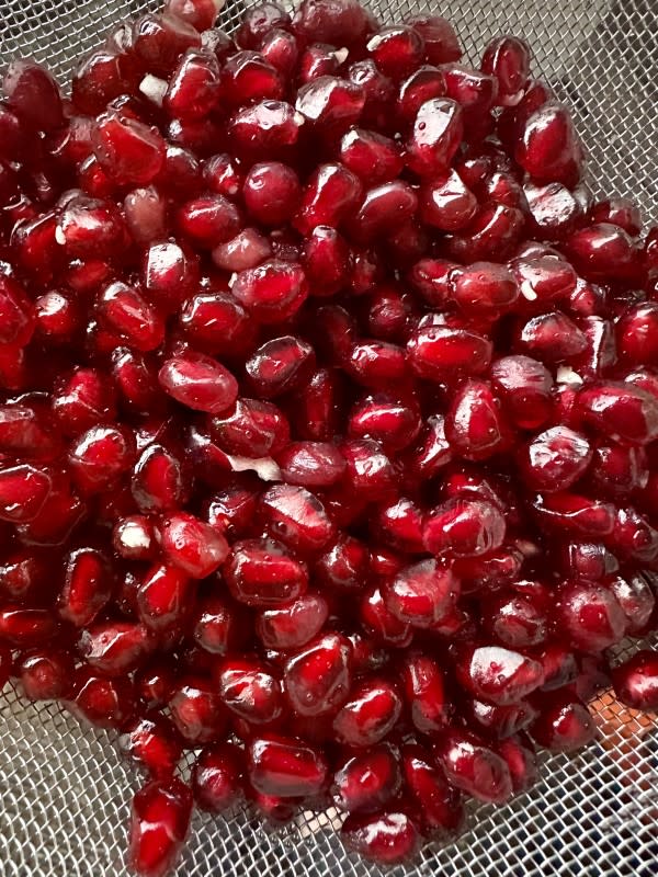 Pomegranate arils in a colander<p>Nina Elder</p>