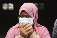 A woman weeps as her house was destroyed by the eruption Mount Semeru in Lumajang district, East Java province, Indonesia, Sunday, Dec. 5, 2021. The death toll from eruption of the highest volcano on Indonesia's most densely populated island of Java has risen with scores still missing, officials said Sunday as rain continued to pound the region and hamper the search.(AP Photo/Trisnadi)