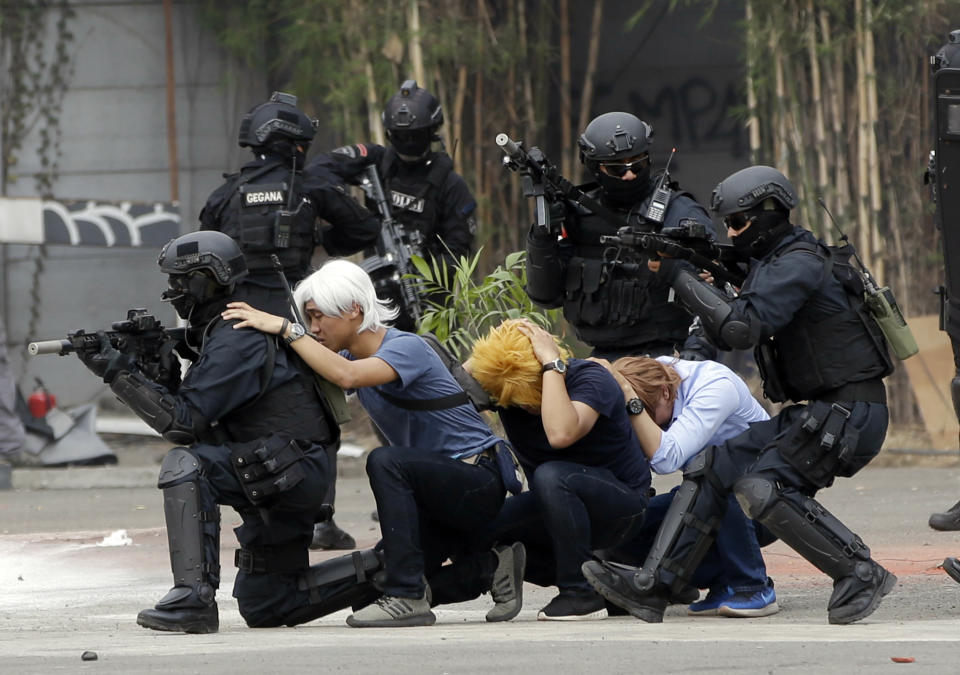 In this July 25, 2018, photo, members of joint Indonesian police and military special forces take part in an anti-terrorism drill ahead of the 2018 Asian Games in Jakarta, Indonesia. Indonesia is deploying 100,000 police and soldiers to provide security for the Asian Games, the biggest event ever held in its terror attack prone capital Jakarta, parts of which have been dramatically spruced up as the city readies to welcome tens of thousands of athletes and visitors. (AP Photo/Tatan Syuflana)