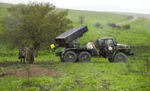 In this grab taken from the Associated Press Television footage made available on Monday, April 4, 2016, Armenian soldiers pass a Grad missile launcher on Sunday, April 3, 2016, in the village of Mardakert, in the separatist region forces of Nagorno-Karabakh. Skirmishes on the volatile Armenia-Azerbaijan border escalated Tuesday, July 14, 2020 marking the most serious outbreak of hostilities between the neighbors since the fighting in 2016. (AP Photo, File)