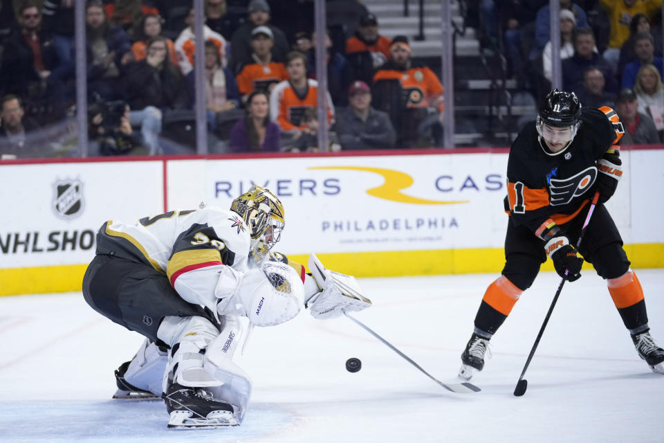 Vegas Golden Knights' Logan Thompson, left, cannot stop the game-winning goal by Philadelphia Flyers' Sean Couturier as Travis Konecny, right, looks on during overtime in an NHL hockey game, Saturday, Nov. 18, 2023, in Philadelphia. (AP Photo/Matt Slocum)