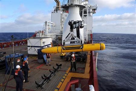 Crew aboard the Australian Defence Vessel Ocean Shield move the U.S. Navy's Bluefin-21 autonomous underwater vehicle into position for deployment in the southern Indian Ocean to look for the missing Malaysia Airlines flight MH370, April 14, 2014 in this handout picture released by the U.S. Navy. REUTERS/U.S. Navy photo by Mass Communication Specialist 1st Class Peter D. Blair/Handout via Reuters