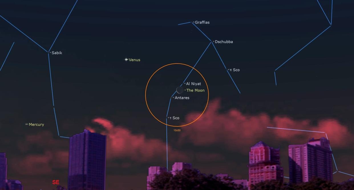  A dim might sky above a short skyline shows a crescent moon near Al Niyat, Antares and Sco, all outline inside an orange-lined circle. 