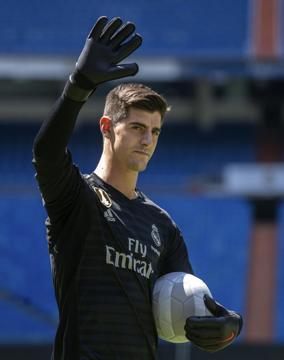 Belgian new Real Madrid soccer player Thibaut Courtois waves to Real Madrid supporters during his official presentation for Real Madrid at the Santiago Bernabeu stadium in Madrid, Thursday, Aug. 9, 2018. Chelsea has sold a player — goalkeeper Thibaut Courtois — to Real Madrid. The Belgian was replaced by Kepa Arrizabalaga after Chelsea met the goalkeeper's 80 million euro ($93 million) buyout clause from Athletic Bilbao on Wednesday. (AP Photo/Andrea Comas)