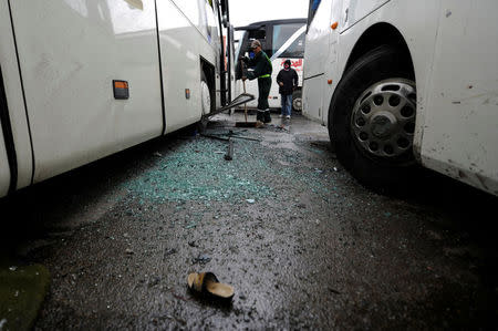 A worker clears shattered glass at the site of an attack by two suicide bombers in Damascus, Syria March 11, 2017. REUTERS/Omar Sanadiki