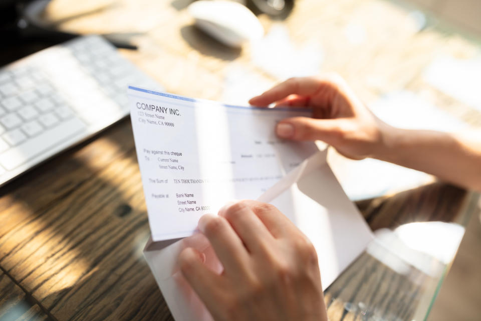 Stock picture of a woman looking at her pay packet. (Getty Images)