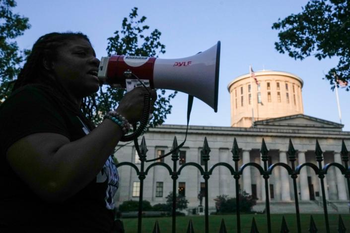 May 20, 2023; Columbus, Ohio, US;  LaQuisa Richardson, CEO of community group Aadvocate, Connect and Empower, speaks into a megaphone in front of the Ohio Statehouse during a protest for Sinzae Reed, a 13-year-old who was shot and killed in Columbus&#x002019; Hilltop neighborhood on Oct. 12, 2022 by Krieg Butler. A Franklin County grand jury recently declined to file murder charges for Butler. 