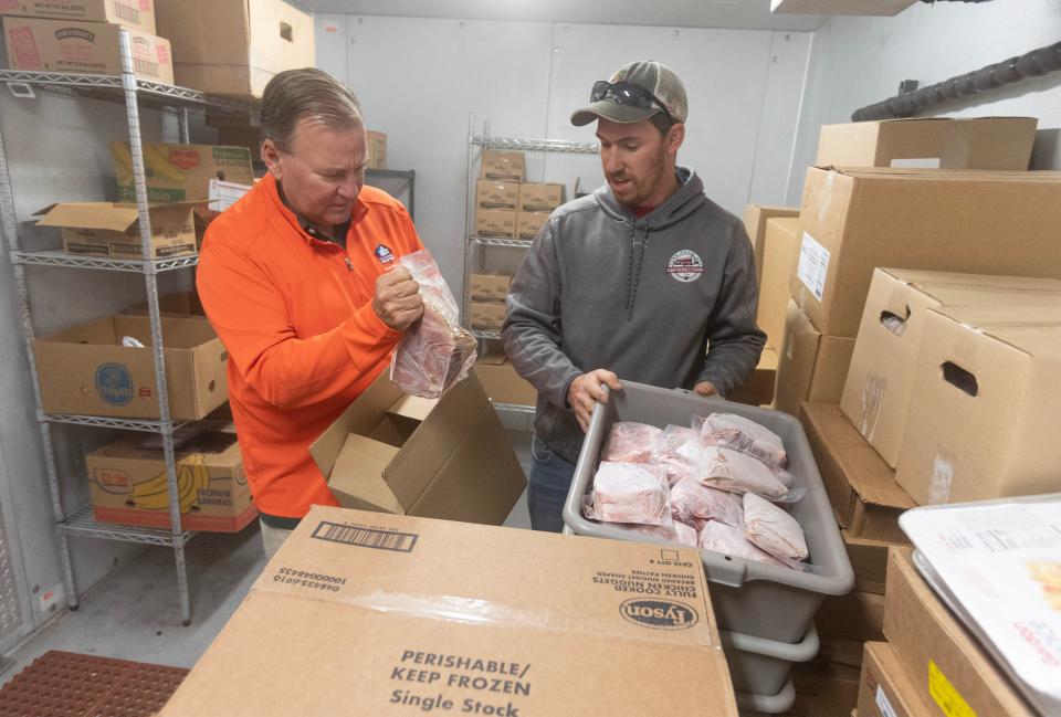 Stark County Commissioner Richard Regula, left, and Jack Flinner of G&F Family Farms in Navarre help deliver nearly 200 pounds of pork last week to the Salvation Army in Massillon. The meat will be given to local families in need.