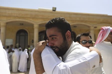 Relatives of the victims of Friday bombing console each other at the Al Jafariya cemetery in Suleibikhat, Kuwait June 27, 2015. REUTERS/Jassim Mohammed