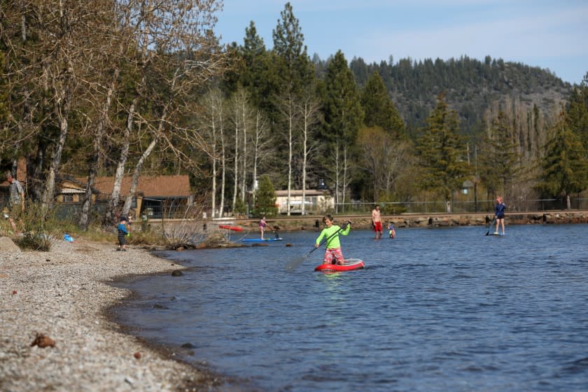 TAHOE VISTA, CA -- MAY 07: People enjoy the public beach on the north shore of Lake Tahoe on Thursday, May 7, 2020, in Tahoe Vista, CA. Cities and counties that live off tourism are strategizing for how to prepare for an influx in out-of-towners when coronavirus restrictions are lifted. (Gary Coronado / Los Angeles Times)