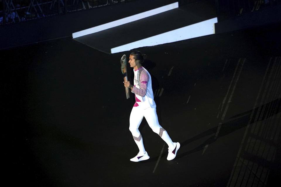 England's Kim Daybell carries the baton during the opening ceremony of the Commonwealth Games at the Alexander Stadium in Birmingham, England, Thursday July 28, 2022. (Zac Goodwin/PA via AP)