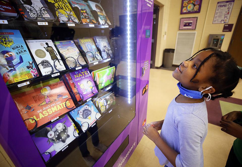 Pickerington Elementary third-grader Janae Jordan looks over the selection in the new book vending machine Feb. 9.