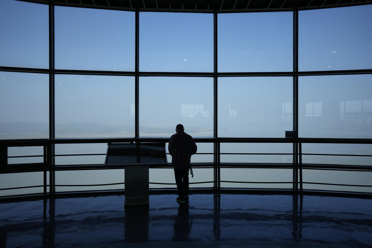 A visitor looks at the northern side from the unification observatory in Paju, South Korea, Wednesday, April 19, 2023. North Korean leader Kim Jong Un said his country has completed the development of its first military spy satellite and ordered officials to go ahead with its launch as planned, state media reported Wednesday. (AP Photo/Lee Jin-man)