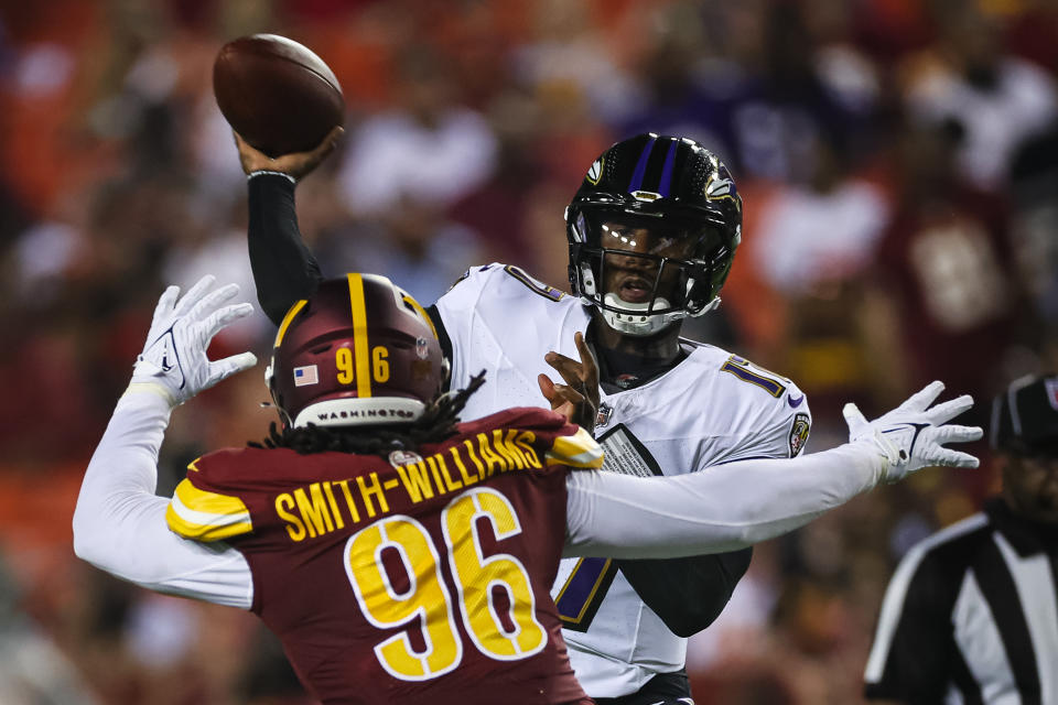 Josh Johnson #17 of the Baltimore Ravens attempts a pass while under pressure from James Smith-Williams #96 of the Washington Commanders. (Photo by Scott Taetsch/Getty Images)