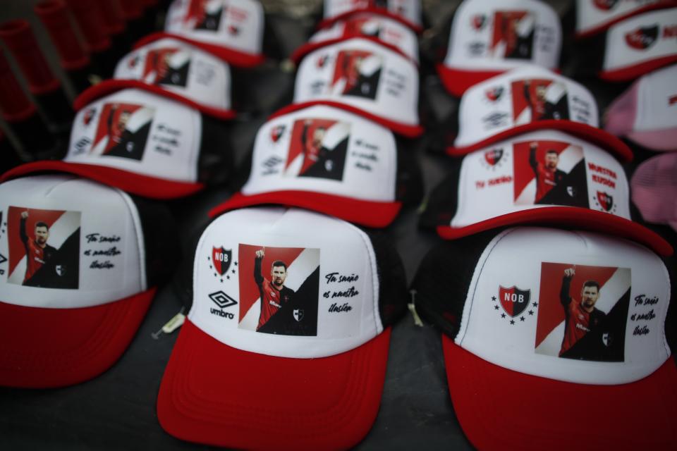 Caps depicting Lionel Messi with a message that reads in Spanish: "Your dream is our illusion," are displayed for sale on the route of a caravan organized by Newell's Old Boys soccer club in Messi's hometown, in Rosario, Argentina, Thursday, Aug. 27, 2020. Fans hope to lure him home following his announcement that he wants to leave Barcelona F.C. after nearly two decades with the Spanish club. (AP Photo/Natacha Pisarenko)