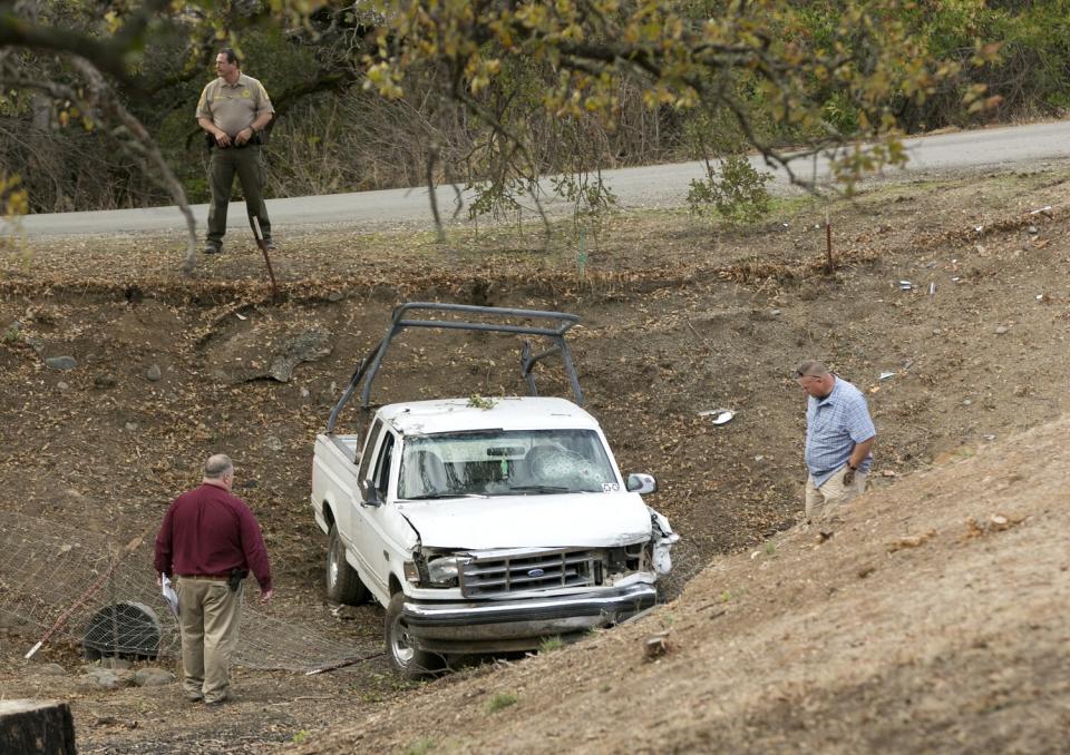 Men stand near a truck.