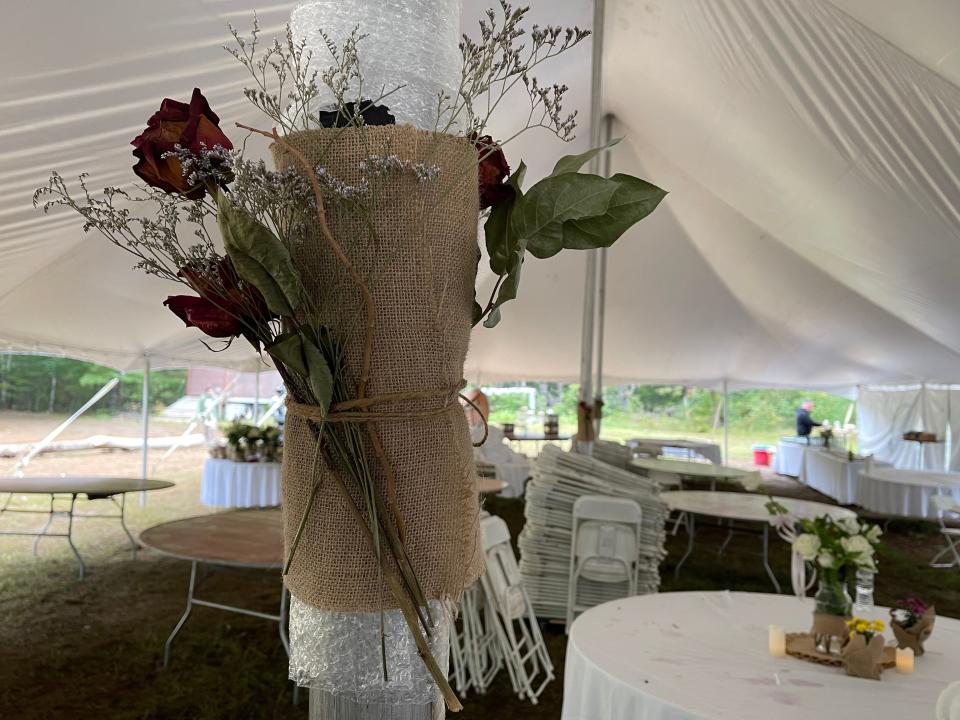 Tent poles wrapped with bubble wrap, with burlap and flowers decorating it.