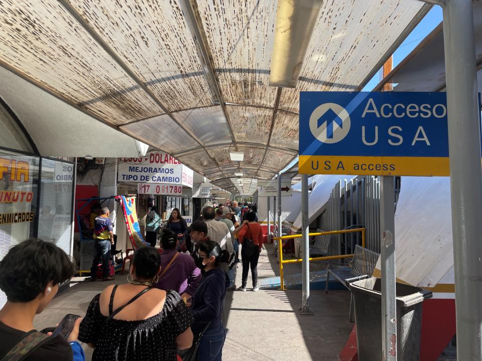 Several dozen people wait in line to cross into the U.S. through the Dennis DeConcini Port of Entry in Nogales, Sonora, on Friday, May 12, 2023. The line is normal if not shorter than at other days and times.