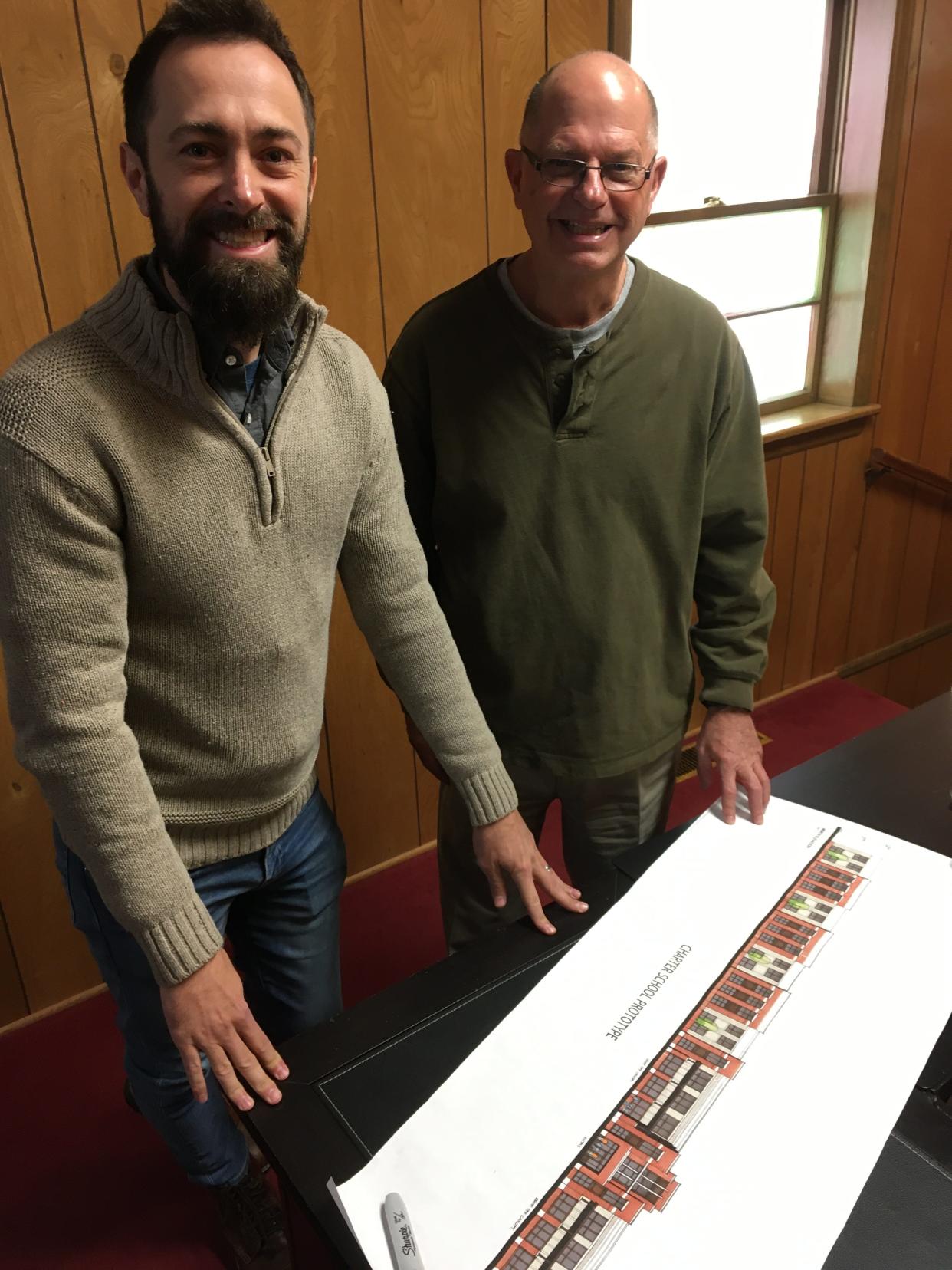 Philip McGinnis (left) and Eddie McGinnis look over the plans for the new building for Stanley's Community Public Charter School.