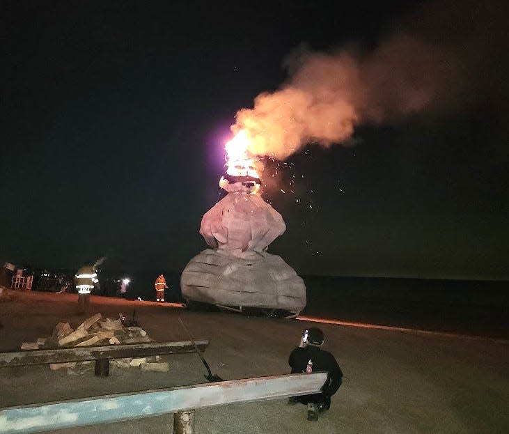 The snowman is lit as a crowd gathers in Port Clinton.