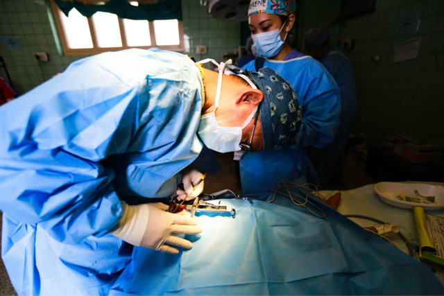 Bent on making a change: Chairman of The Smile Mission Vincent Yeow, who is also an internationally-renowned plastic surgeon, is pictured here intently working on a patient's face in the operating theatre. Photo credit: Smile Asia Facebook page