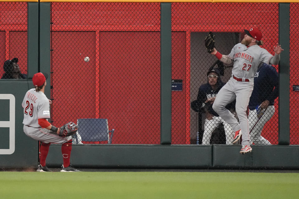 A home run by Atlanta Braves' Eddie Rosario goes over the heads of Cincinnati Reds center fielder TJ Friedl (29) and right fielder Jake Fraley (27) during the eighth inning of a baseball game Wednesday, April 12, 2023, in Atlanta. (AP Photo/John Bazemore)