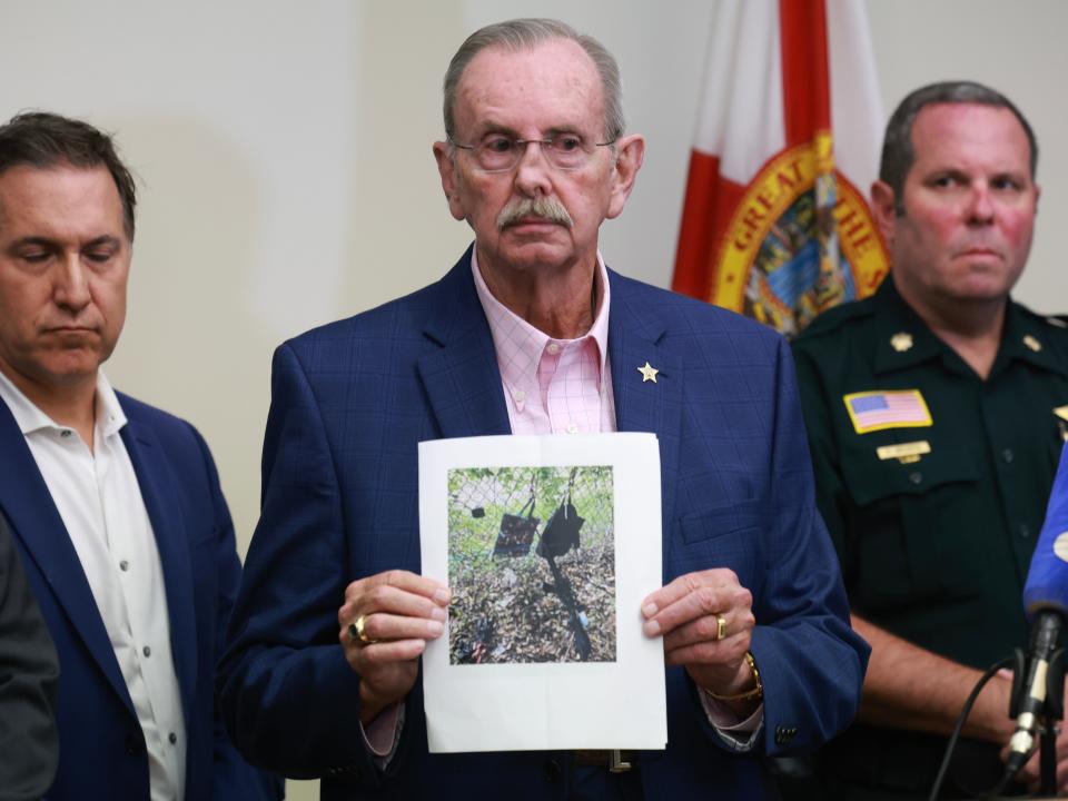 Palm Beach County Sheriff Ric Bradshaw holds a photograph