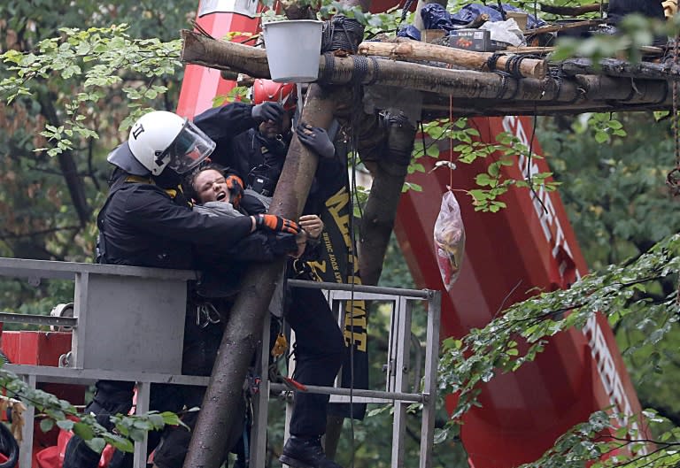 Policemen on a lifting platform drag an environmental activist from a so-called Tripod tree house in the Hambacher Forst forest which the protesters are trying to save from being razed for a nearby coal mine