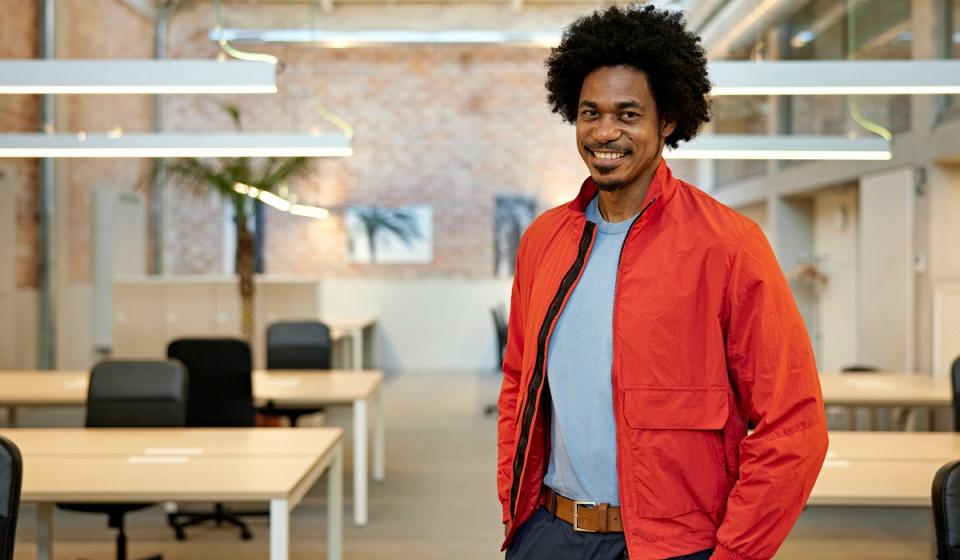 A man wearing his red jacket in an office