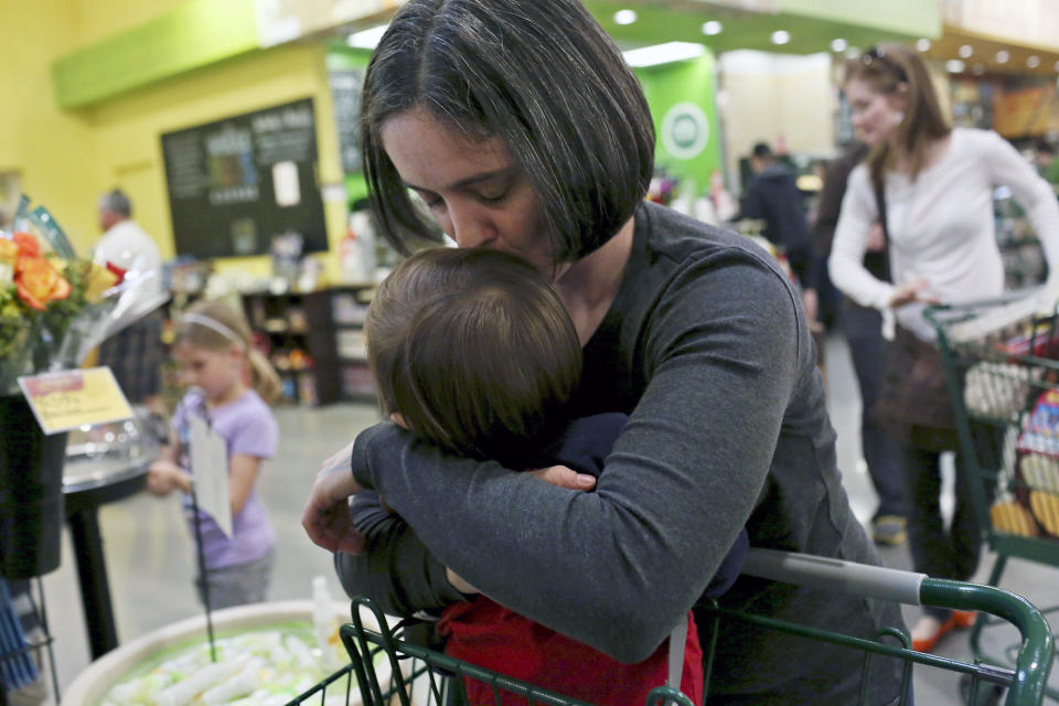In this Feb. 8, 2014 photo, Nicole Dimetman kisses her son while waiting in the checkout line at Whole Foods in Austin, Texas A federal judge is expected to hear arguments Wednesday, Feb. 12, 2014, in a lawsuit brought by two homosexual couples who say the Texas Constitution’s ban on gay marriage is unconstitutional because it denies them the right to be treated like everyone else. (AP Photo/The San Antonio Express-News, Lisa Krantz) RUMBO DE SAN ANTONIO OUT; NO SALES; MAGS OUT