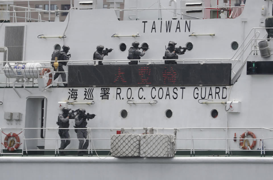 Crew members of the Taiwan Coast Guard perform during an offshore anti-terrorism drill outside the Kaohsiung harbor in Kaohsiung, southwestern Taiwan, Saturday, June 10, 2023. During Saturday's drills, Taiwanese security officers demonstrated how they would defend against terrorist acts at sea. Some climbed from small boats onto a vessel controlled by “terrorists” and brought them under control. Others rappelled down from a flying helicopter. The stimulation ended with a dramatic scene in which some officers hung in the air as they were sent back to the helicopter. (AP Photo/Chiang Ying-ying)