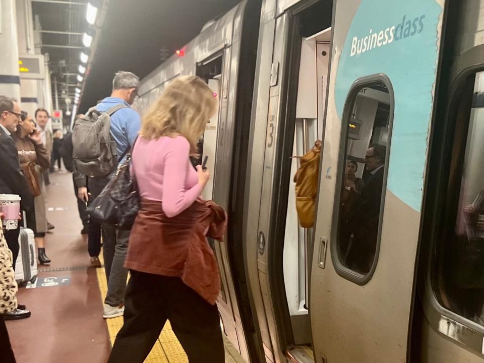 A woman in a pink shirt boarding the Acela train.