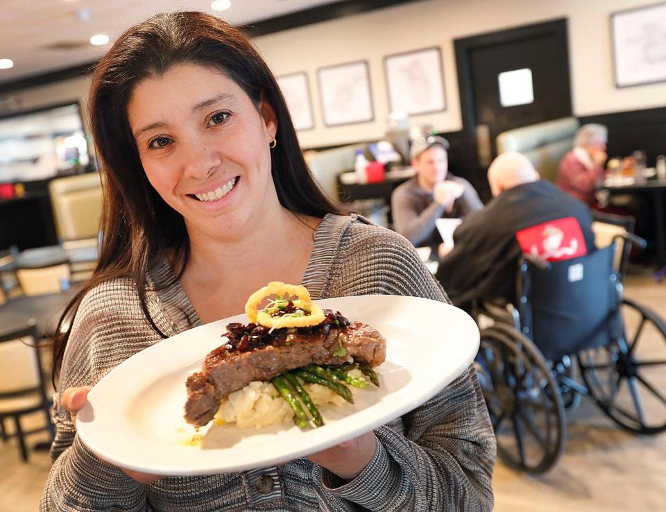 Owner Michelle Doran with a sirloin steak on a bed of mashed potatoes topped with onion jam at Mad Hatter in Weymouth.