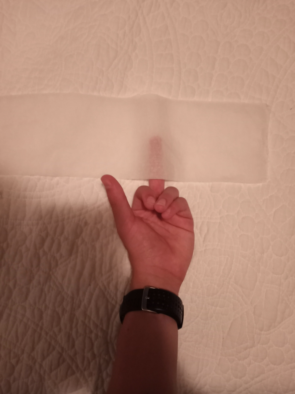 A person giving the middle finger through thin toilet paper