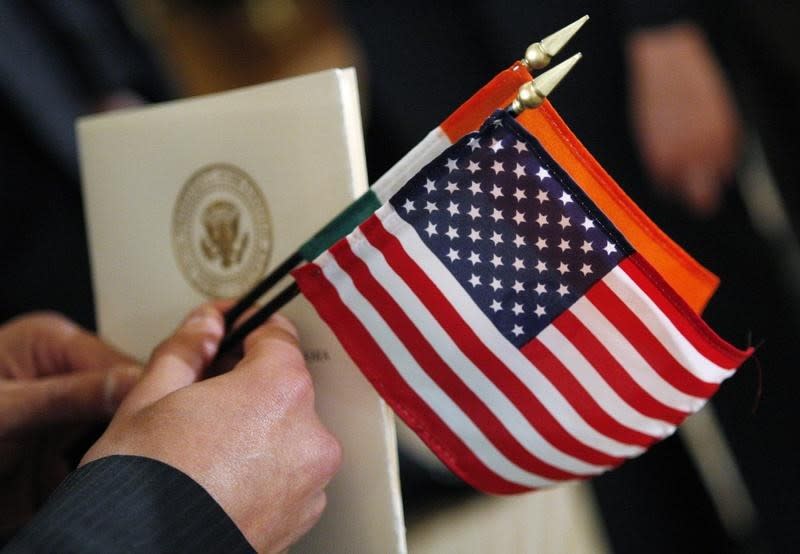 A guest holds the flags of the United States and India and a program as U.S. President Barack Obama welcomes former Prime Minister Manmohan Singh at an official arrival ceremony in the East Room at the White House in Washington, November 24, 2009. REUTERS/Jim Young/Files