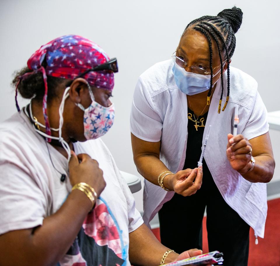 Retired Registered Nurse Shirley Holston, right, shows Warren Gordon, left, that he is getting his second and final Moderna shot as Heart of Florida nurses worked on vaccinating people Friday afternoon, May 21, 2021 in the Heart of Florida Health Center's Vaccine Annex.