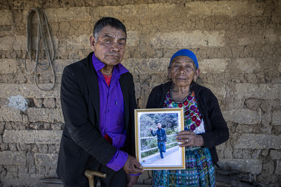 German and Maria Tomas pose for a photograph holding a framed portrait of their grandson Ivan Gudiel, at their home in Comitancillo, Guatemala, Wednesday, Jan. 27, 2021. They believe their grandson is one of the 13 of the 19 charred corpses found in a northern Mexico border state on Saturday. The country's Foreign Ministry said it was collecting DNA samples from a dozen relatives to see if there was a match with any of the bodies. (AP Photo/Oliver de Ros)