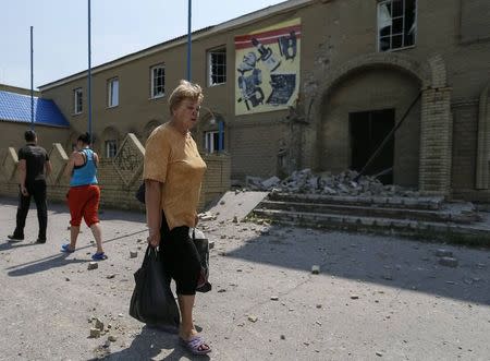 A woman cries as she passes destroyed houses following what locals say was overnight shelling by Ukrainian forces, in the eastern Ukrainian town of Slaviansk June 9, 2014. REUTERS/Gleb Garanich