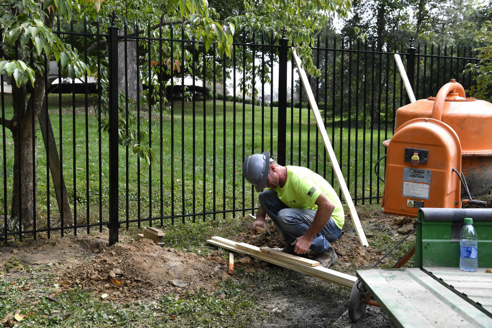 Workers with Stewart Construction install a security fence around the Governors' Mansion on the grounds of the Kentucky State Capitol in Frankfort, Ky., Friday, Oct. 9, 2020. Security is being increased following a plot to kidnap the Governor of Michigan, and Gov. Andy Beshear, a Democrat, was hanged in effigy from a tree during a May protest against his COVID-19 restrictions on the state Capitol grounds in Frankfort. (AP Photo/Timothy D. Easley)