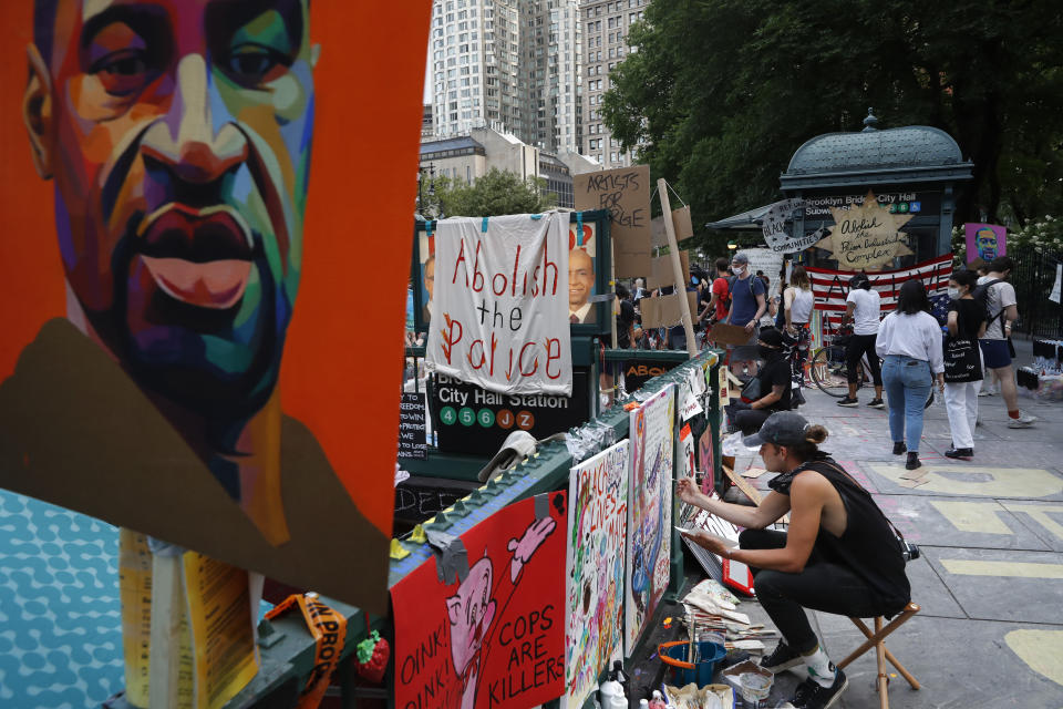 Protesters hang signs and artwork at a subway station entrance at an encampment outside City Hall, Friday, June 26, 2020, in New York. (AP Photo/John Minchillo)
