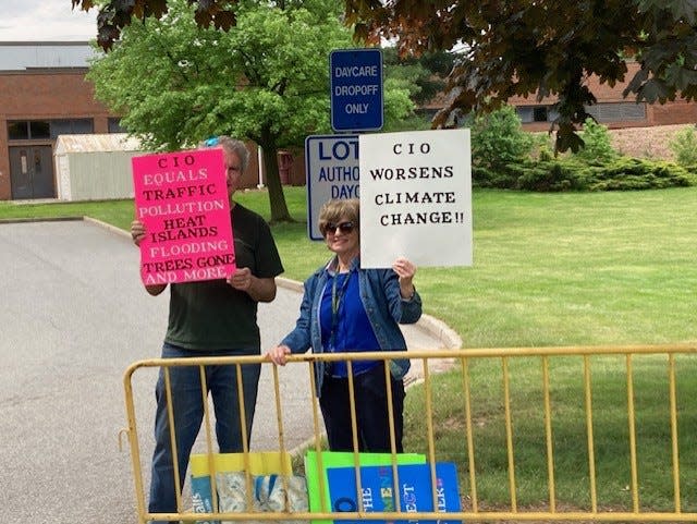 Elisabeth Oliu, of Metuchen, was one of two people protesting the planned new development projects on the campus of Middlesex College in Edison on Tuesday.