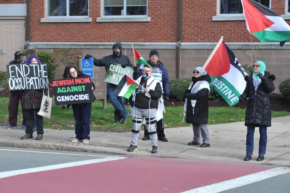 Palestinian supporters get the attention of drivers on Washington Street near Braintree Town Hall. They are calling for an end to Israel's military action in Gaza, Sunday, Dec. 31, 2023.